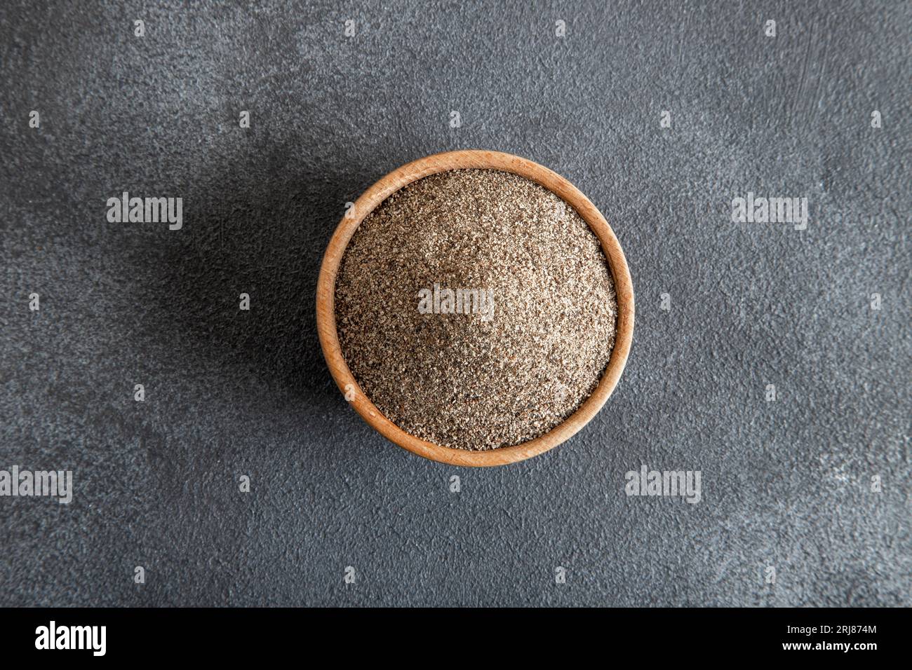 Schwarzer Pfeffer auf schwarzem Hintergrund, Draufsicht Stockfoto