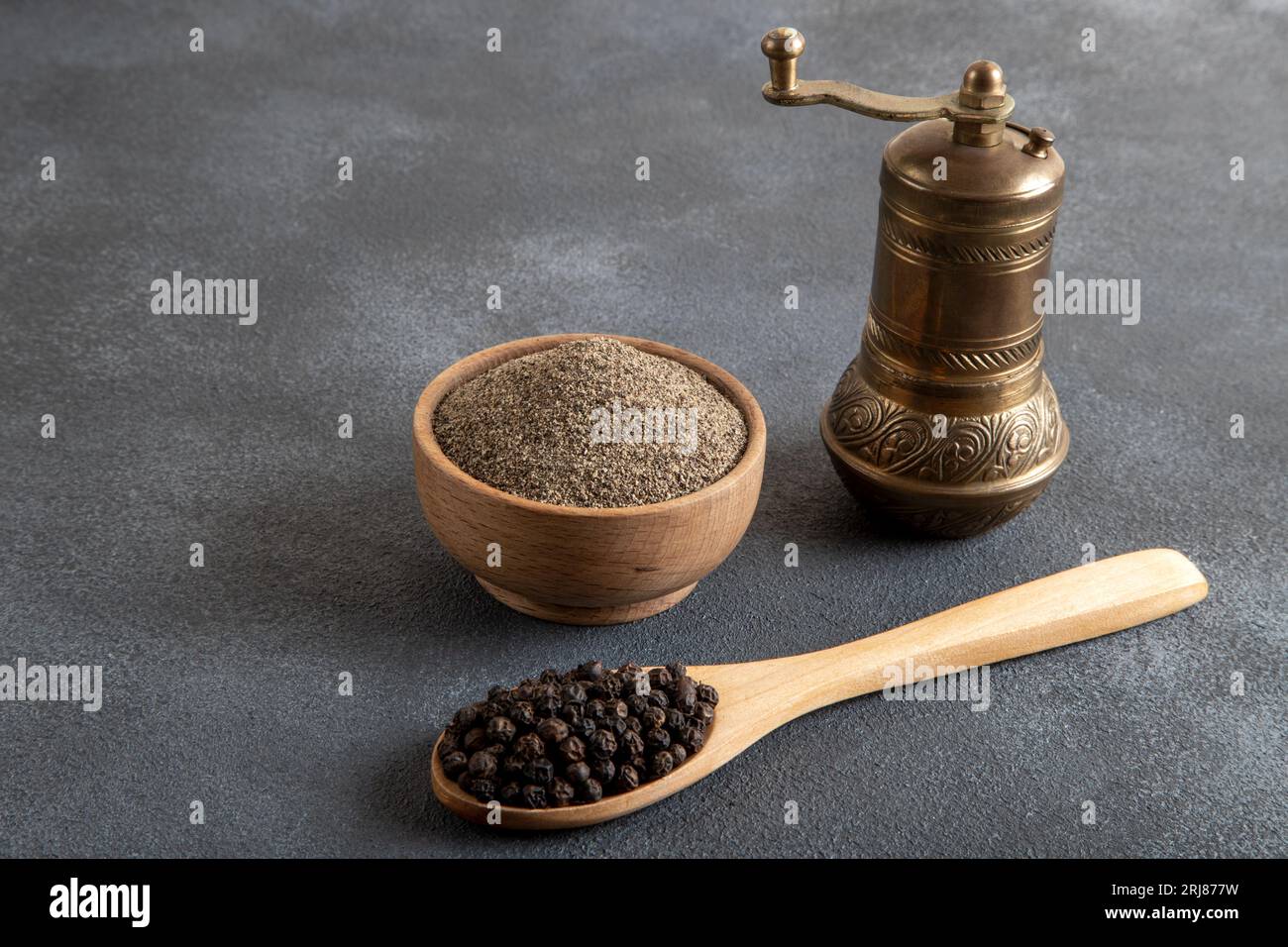 Schwarze Pfefferkörner, gemahlener schwarzer Pfeffer und Metallmühle, Draufsicht Stockfoto