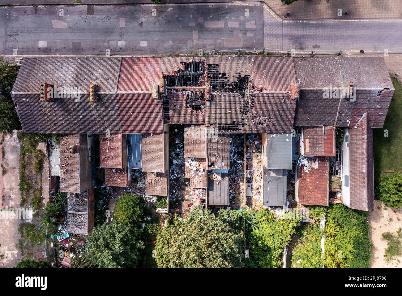 Luftaufnahme direkt über einem Terrassengebäude mit beschädigtem Dach nach einem Hausbrand Stockfoto
