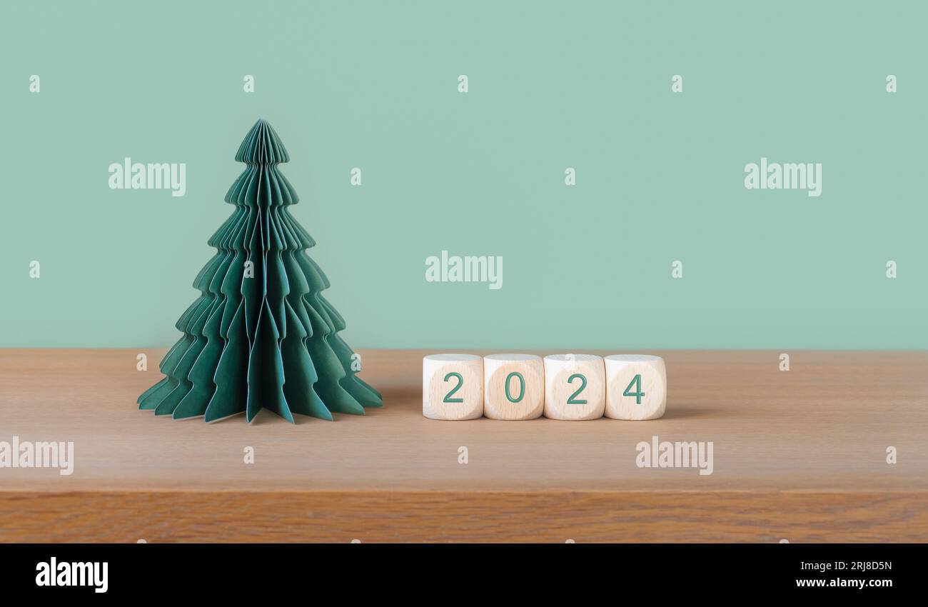 Weihnachten und Neujahr 2024 Hintergrund mit Papierbaum und Würfeln 