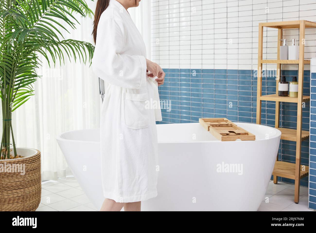Beauty Concept Foto von koreanischer asain schöne Frau in einem Bademantel in einem Badezimmer mit Badewanne Stockfoto