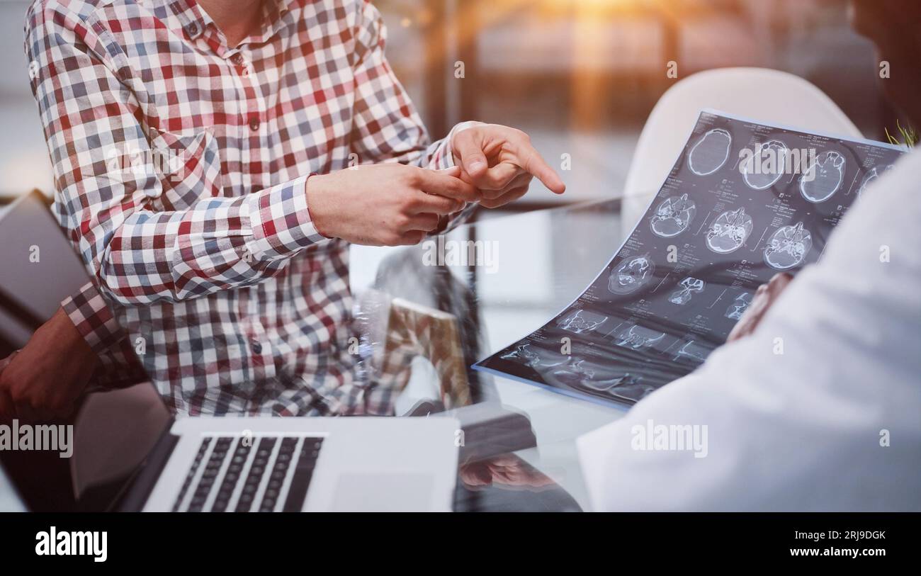 Der Arzt und der Patient an der Rezeption besprechen das Röntgenbild Stockfoto