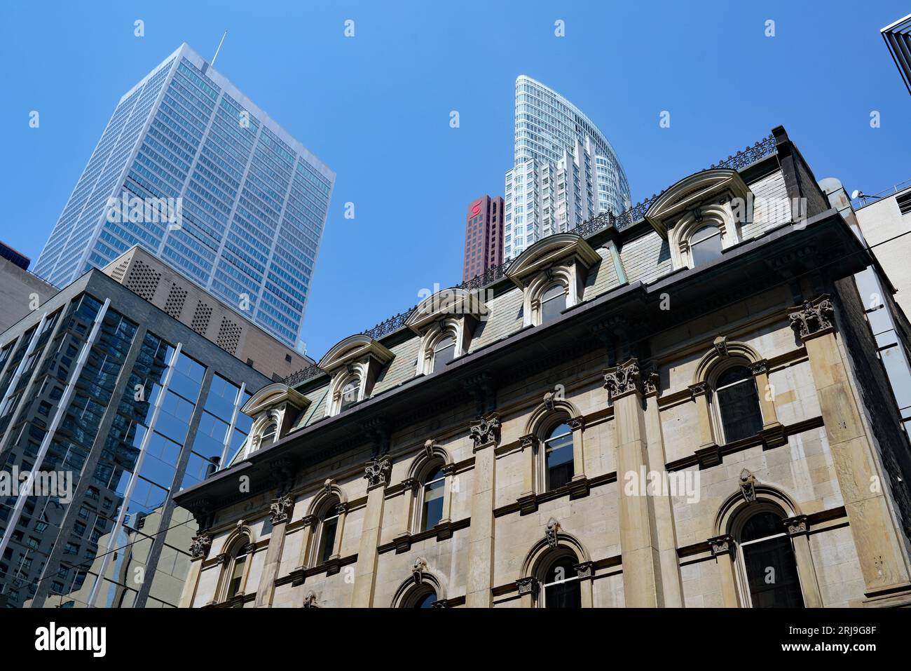 Ein Bankgebäude aus den 1870er Jahren an der King Street in Toronto mit modernen Wolkenkratzern im Hintergrund Stockfoto