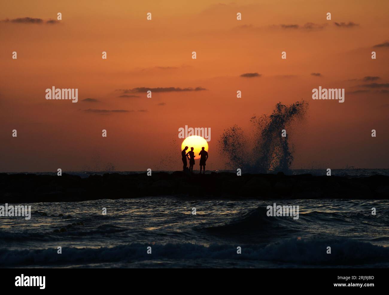 Freunde genießen den wunderschönen Sonnenuntergang am Strand in Tel-Aviv, Israel. Stockfoto