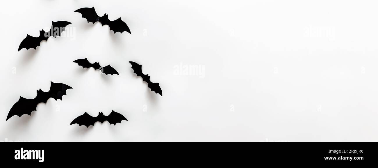 Dekorative Fledermaus-Silhouetten-Aufkleber an der weißen Wand. Halloween-Banner mit Platz für Text Stockfoto