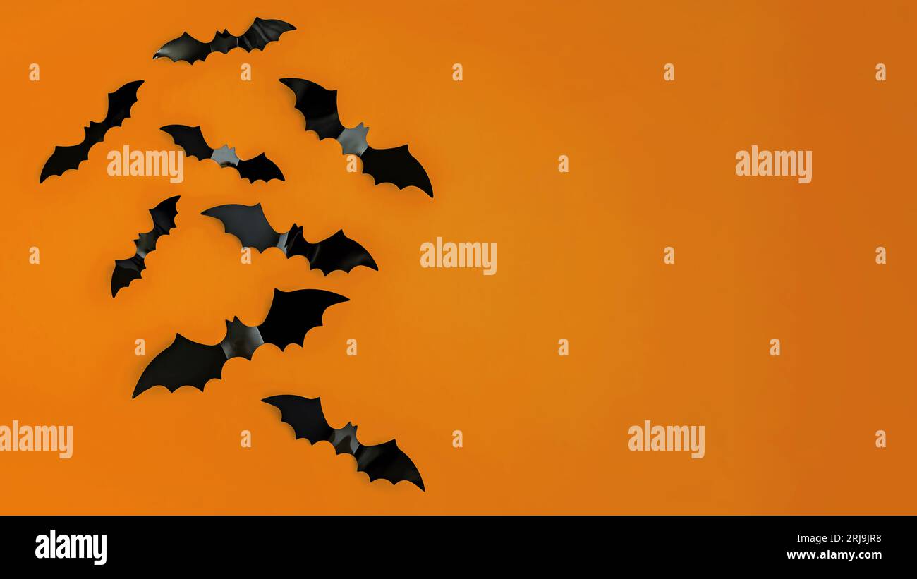 Dekorative Aufkleber mit Fledermaus-Silhouette an der orangefarbenen Wand. Halloween-Banner mit Platz für Text Stockfoto