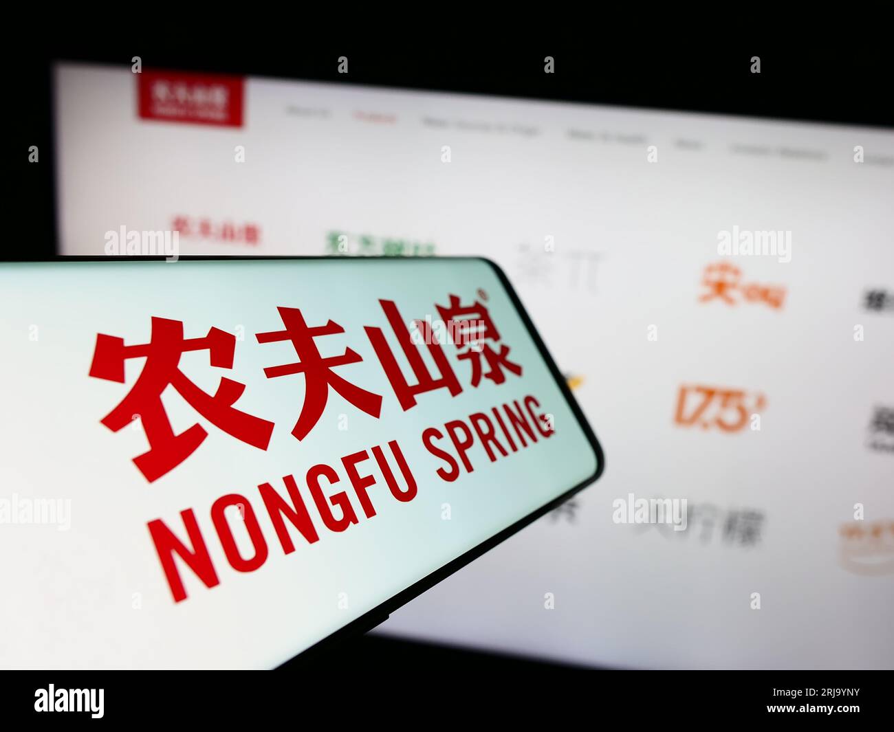 Mobiltelefon mit Logo des chinesischen Unternehmens Nongfu Spring Company Limited auf dem Bildschirm vor der Website. Konzentrieren Sie sich auf die Mitte-links-Anzeige des Telefons. Stockfoto