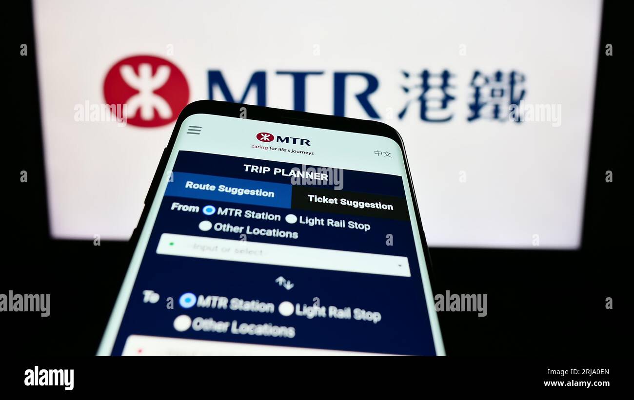 Smartphone mit Website der chinesischen Eisenbahngesellschaft MTR Corporation Limited auf dem Bildschirm vor dem Firmenlogo. Konzentrieren Sie sich auf die obere linke Ecke des Telefondisplays. Stockfoto