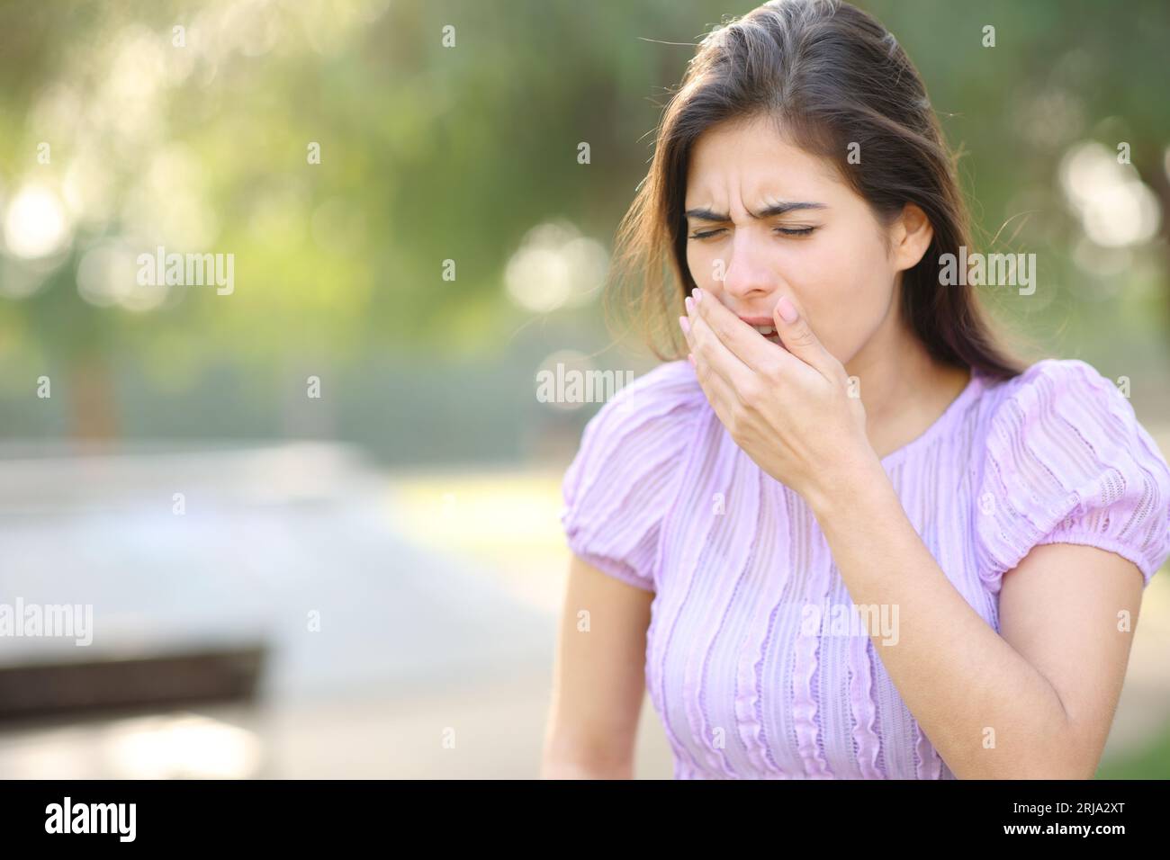 Frau, die hustet, läuft in einem Park Stockfoto