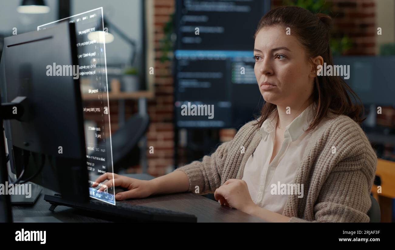 Qualifizierter Programmierer, der durch AR-Technologie unterstützt wird, um Skript zu visualisieren und Code auf dem Computerbildschirm zu schreiben, während er am Arbeitsplatz Java-Programmiersprachen verwendet. Zertifizierter Techniker, der Fehler löst Stockfoto
