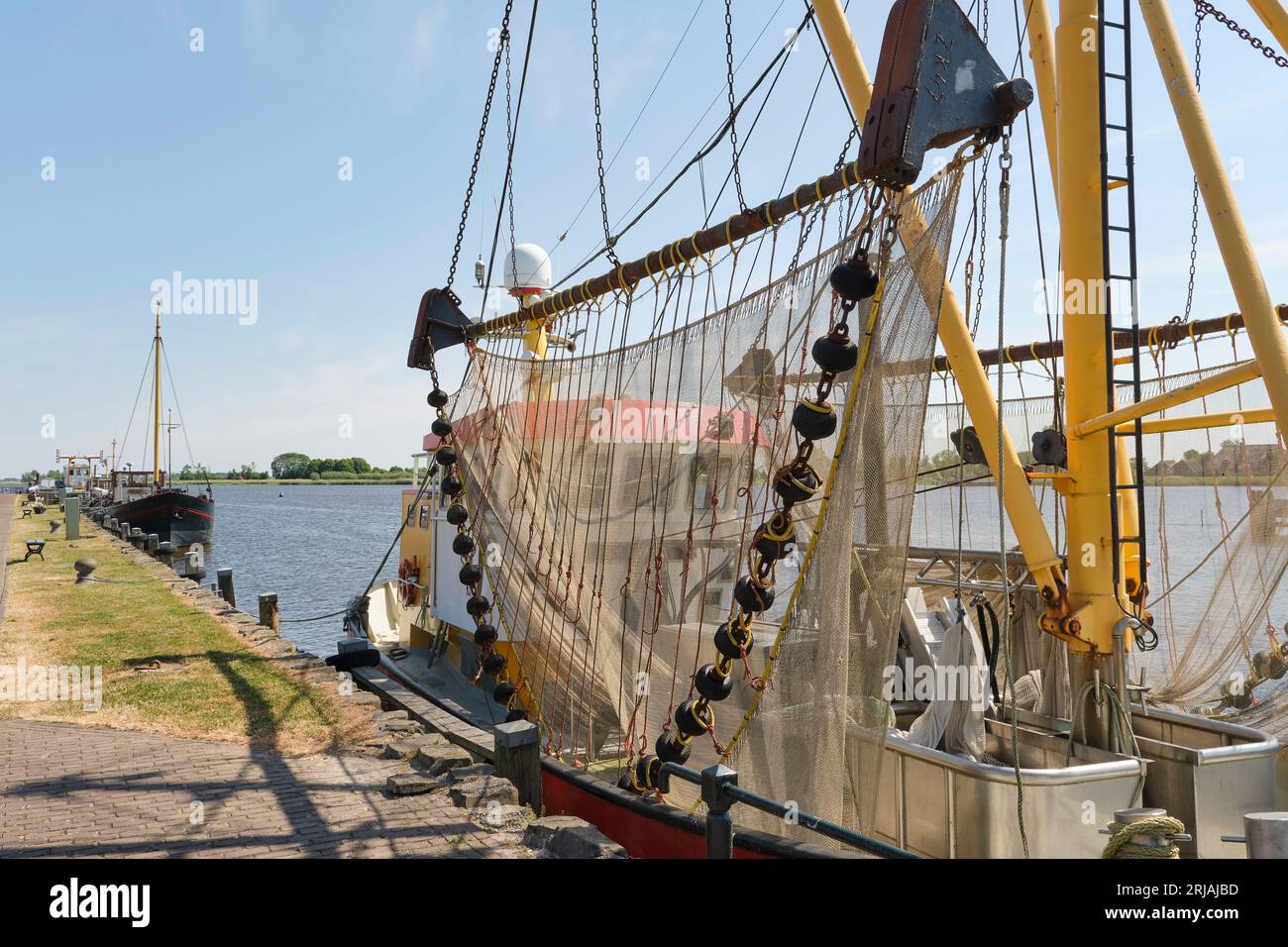 Garnelenboot mit Netzen im Hafen von Zoutkamp Groningen in den Niederlanden. Die Garnelenfischerei und -Verarbeitung ist eine wichtige Branche in Zoutkamp. Stockfoto