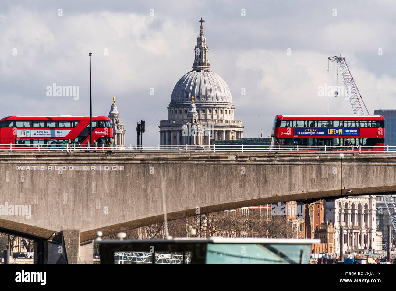 2 rote Londoner Busse treffen sich auf der Waterloo Bridge mit dem Dom von St. Pauls im Hintergrund. Stockfoto