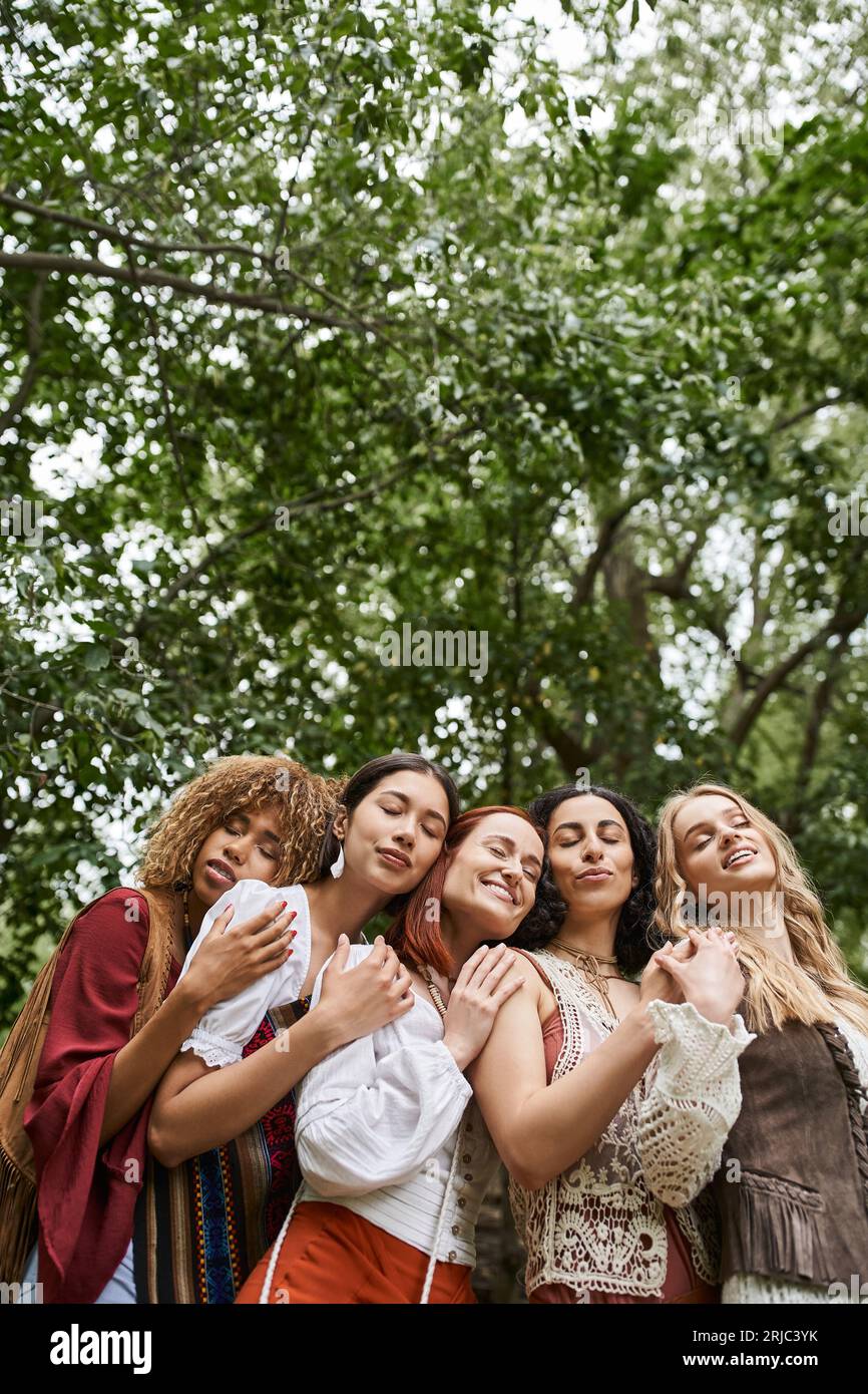 Schwacher Blick auf stilvolle multiethnische lächelnde Frauen mit geschlossenen Augen im Retreat Center Stockfoto