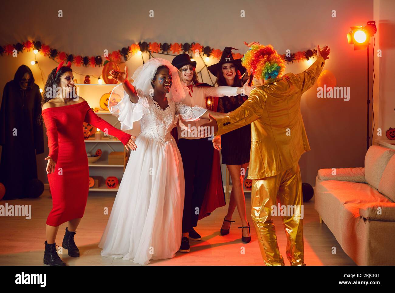 Eine Gruppe glücklicher junger Freunde in gruseligen Kostümen trifft sich auf einer lustigen Halloween-Party Stockfoto