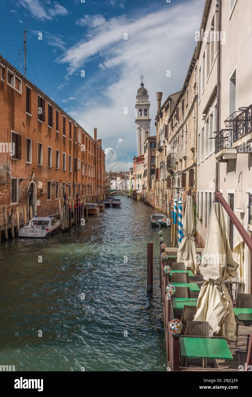 Schmaler Wasserkanal in Venedig, gesäumt von historischer europäischer Architektur. Stockfoto