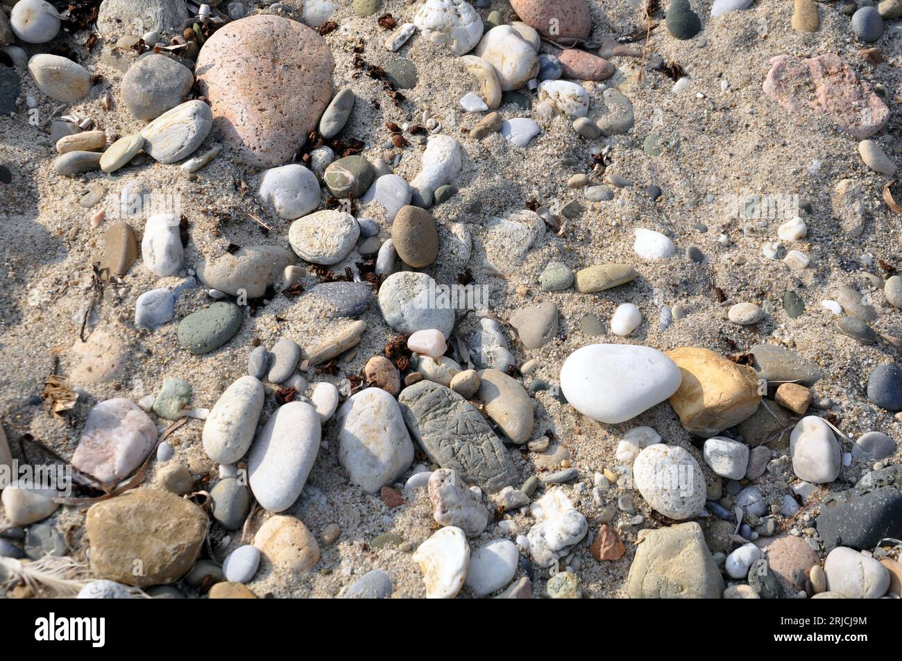 Bunte Steine, Meer und Sand Stockfoto