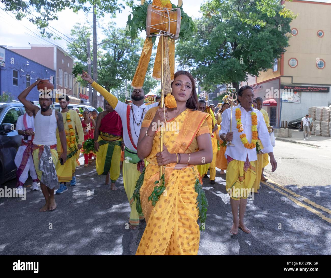Eine Hindu-Frau führt eine Gruppe von ihrem Tempel im Ozone Park zu den spirituellen Stätten von Arya für das Thimithi-Feuerwalzritual. In Queens, New York. Stockfoto