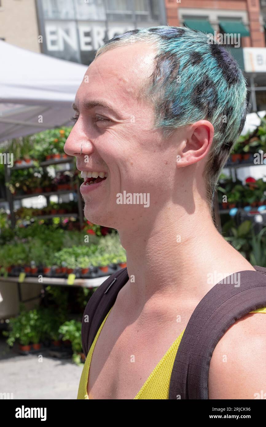 Ein junger Mann mit einem Lächeln und einer sehr üblichen Haarfarbe. Am Union Square Green Market in Manhattan Stockfoto