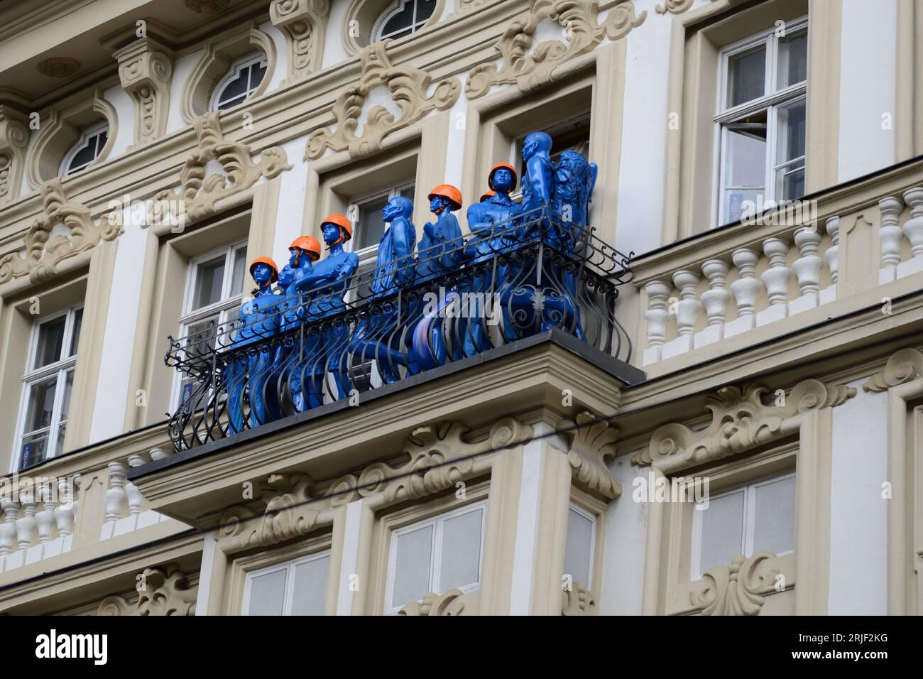 Blaue Schaufensterpuppen von Bauarbeitern auf einem Balkon in Innsbruck Stockfoto