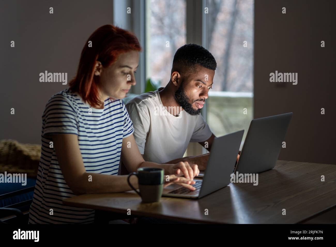 Seriöser schwarzer Mann und Frau, die an Laptops arbeiten. Fokussierte Mitarbeiter konzentrieren sich auf Online-Arbeit Stockfoto