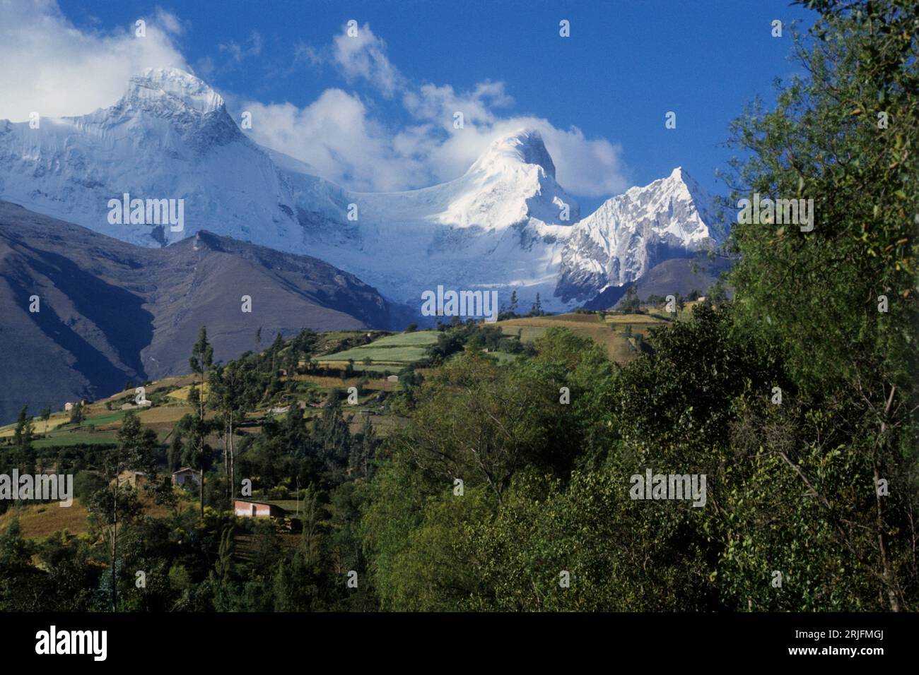 Peru, Andengebirge - Cordillera de los Andes. Cordillera Blanca. Der schneebedeckte Mount Huandoy. Siedlungen und Felder im Vordergrund. Stockfoto