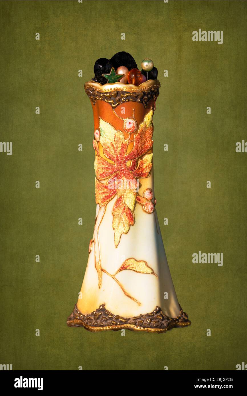 Ein sehr dekorativer alter Schulhalter für Hutnadeln für Damen auf einem rustikalen grünen Hintergrund, der für die richtige Kleidung für High-Fashion-Veranstaltungen erforderlich ist Stockfoto