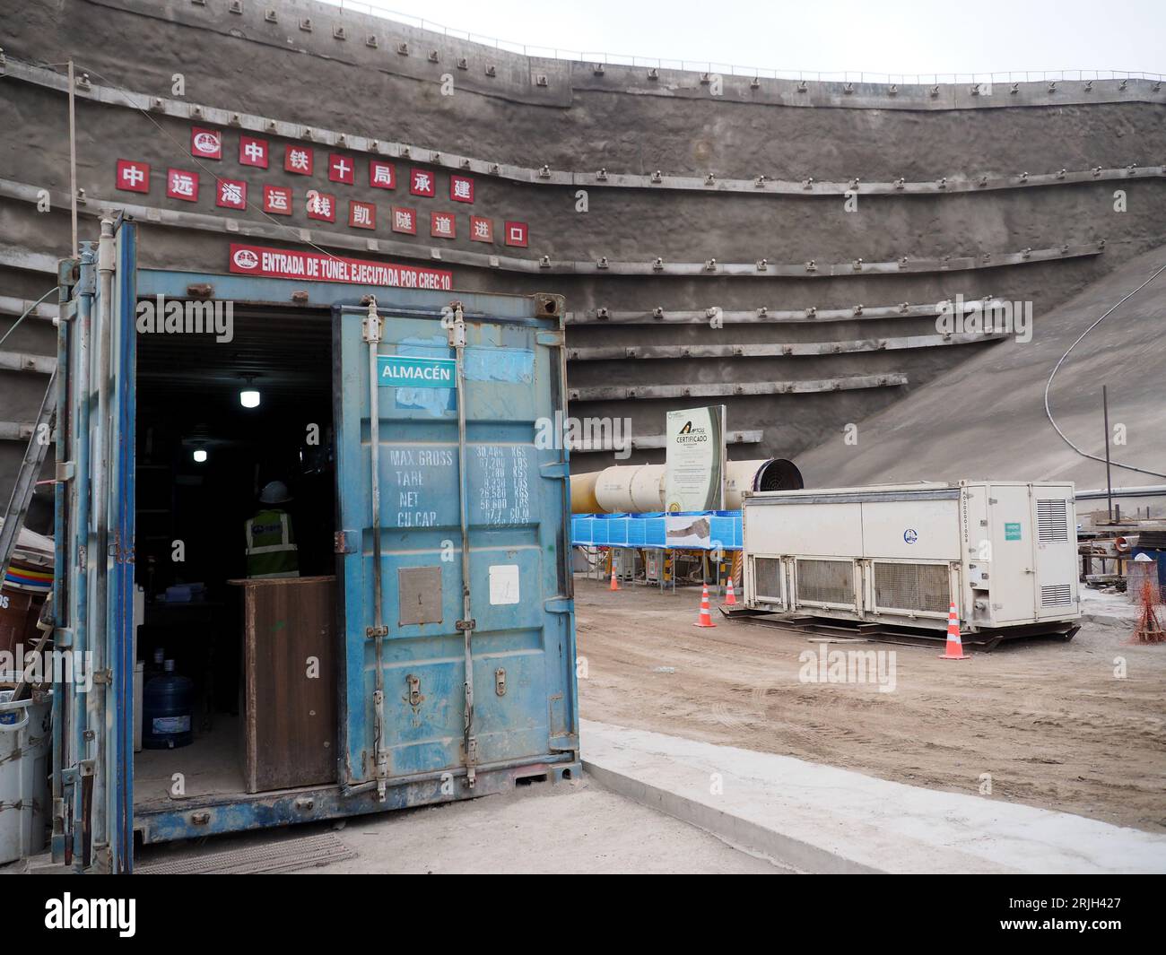 Tunneltor zu den noch im Bau befindlichen Hafenanlagen von Chancay an der peruanischen Küste, 60 km nördlich von Lima. Der Hafen von Chancay wäre das Drehkreuz des südamerikanischen Pazifiks mit der Kapazität, drei E-Schiffe aufzunehmen, die zwischen 18.000 und 24.000 Container beladen können, weshalb er als Tor des direkten Seeverkehrs von Südamerika nach Asien und Ozeanien gilt. Der Hafen wird von Cosco Shipping aus China gebaut Stockfoto Tunneltor zu den noch im Bau befindlichen Hafenanlagen von Chancay an der peruanischen Küste, 60 km nördlich von Lima. Der Hafen von Chancay wäre das Drehkreuz des südamerikanischen Pazifiks mit der Kapazität, drei E-Schiffe aufzunehmen, die zwischen 18.000 und 24.000 Container beladen können, weshalb er als Tor des direkten Seeverkehrs von Südamerika nach Asien und Ozeanien gilt. Der Hafen wird von Cosco Shipping aus China gebaut Stockfoto