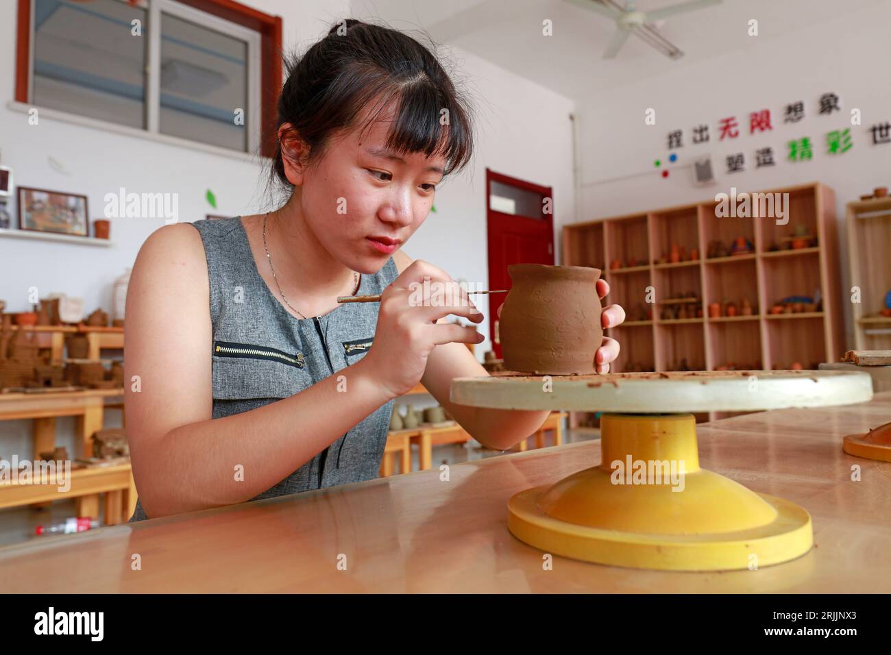 LUANNAN COUNTY, China - 20. Juli 2018: Das Mädchen konzentriert sich auf die Herstellung von Keramikwerken, LUANNAN COUNTY, Provinz Hebei, China Stockfoto
