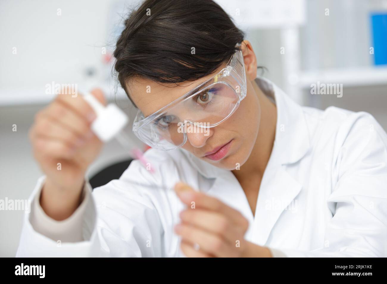Frau mit Pipetten und Reagenzgläsern Stockfoto