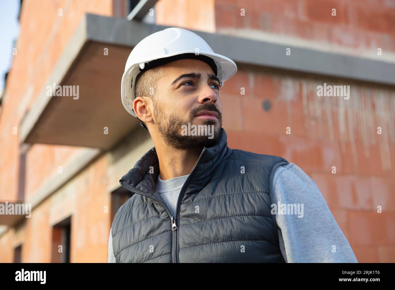 Bauprojekt männlicher Baumeister, der das neue Gebäude überprüft Stockfoto