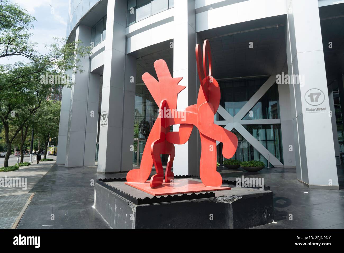 Eine rote Stahlskulptur von Keith Haring befindet sich in der 17 State Street gegenüber der Battery Street. Sie trägt den Titel „Figure Balancing on Dog“. Stockfoto