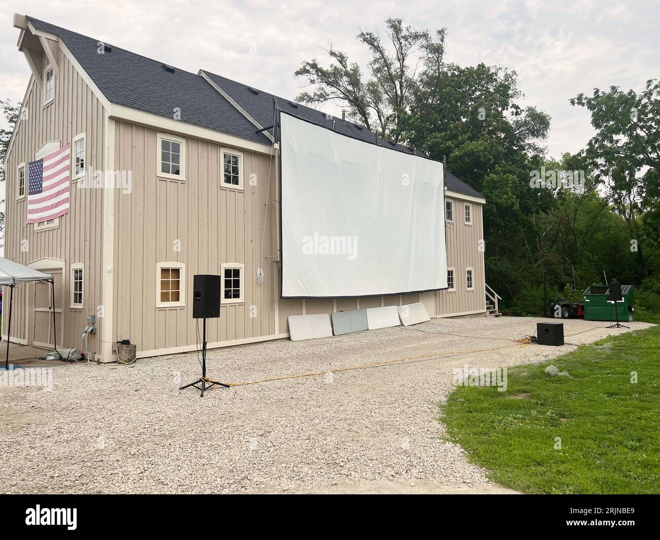 Große Filmleinwand an der Seite einer braunen Scheune mit amerikanischer Flagge Stockfoto