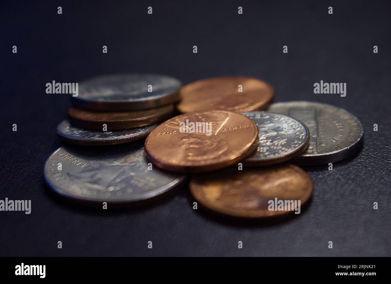 Ein Stapel verschiedener Münzen unterschiedlicher Größe auf einer flachen grauen Oberfläche Stockfoto
