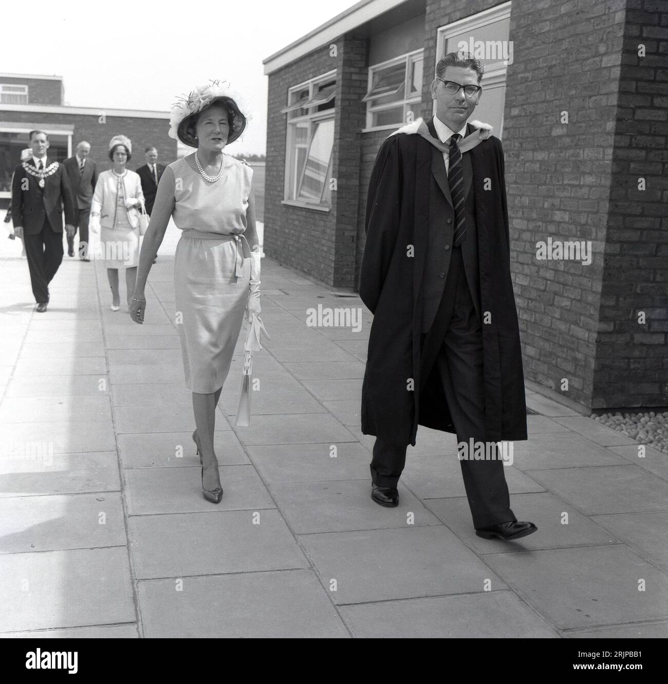 1964, historischer, offizieller Schulbesuch Lady Alexandra Curzon mit Schulleiterin in akademischem Gewand besucht die Mandeville School in Aylesbury, England, zusammen mit anderen Würdenträgern, darunter dem Bürgermeister. Stockfoto