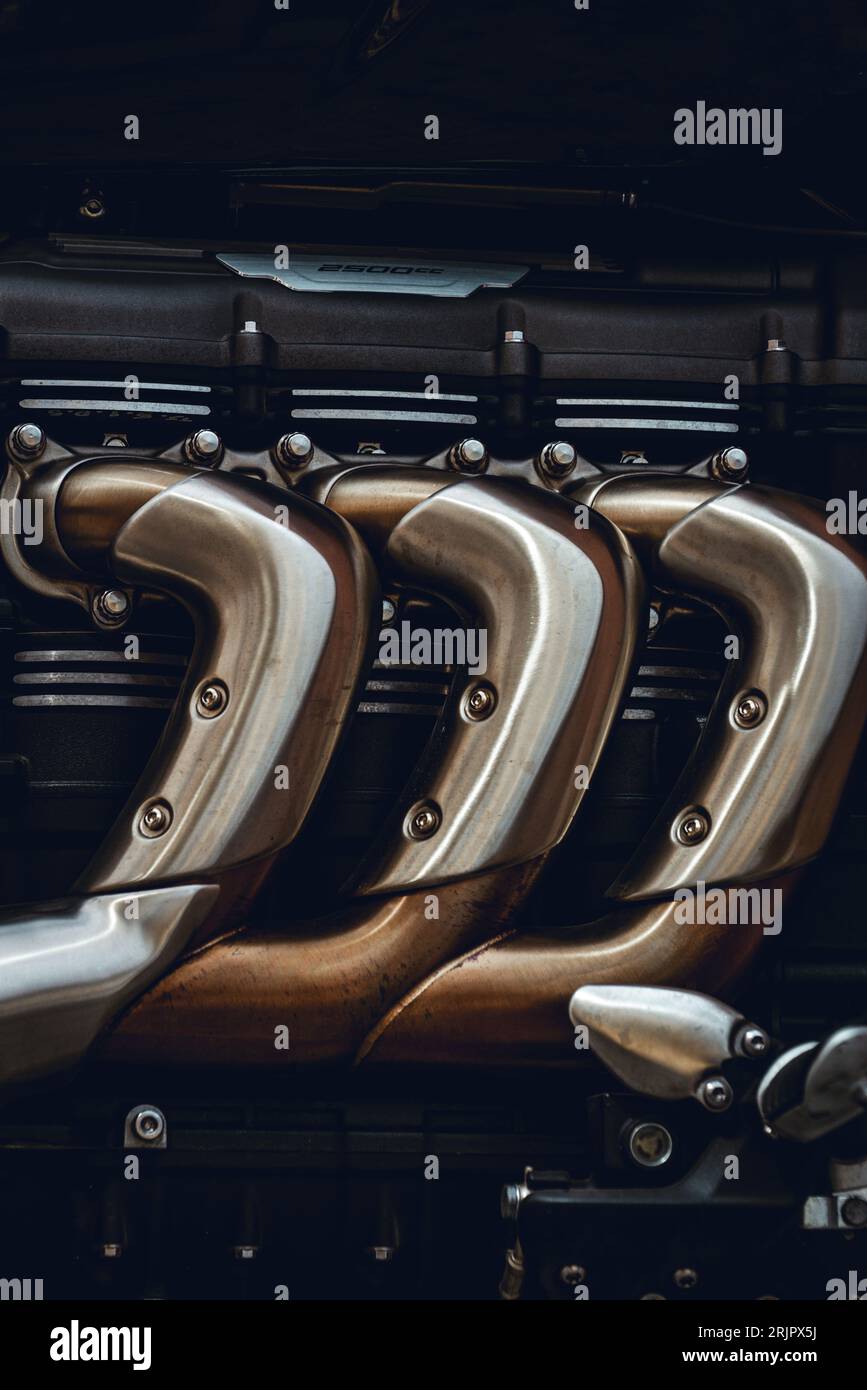 Eine Nahansicht der Motorkomponenten von Motorrädern mit komplizierten Metallrohren in verschiedenen Größen und Farben Stockfoto