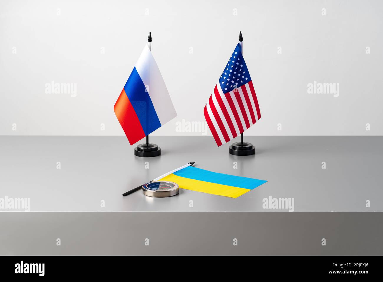 Flaggen der USA, Russlands und der Ukraine auf grauem Hintergrund Stockfoto