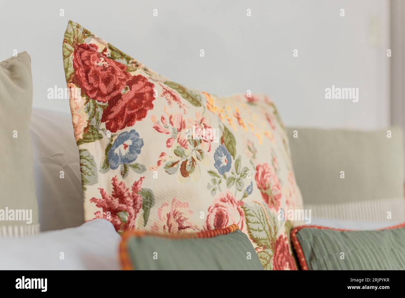 Ein wunderschönes Kissen im Vintage-Stil mit Blumenstickerei auf einer Couch Stockfoto