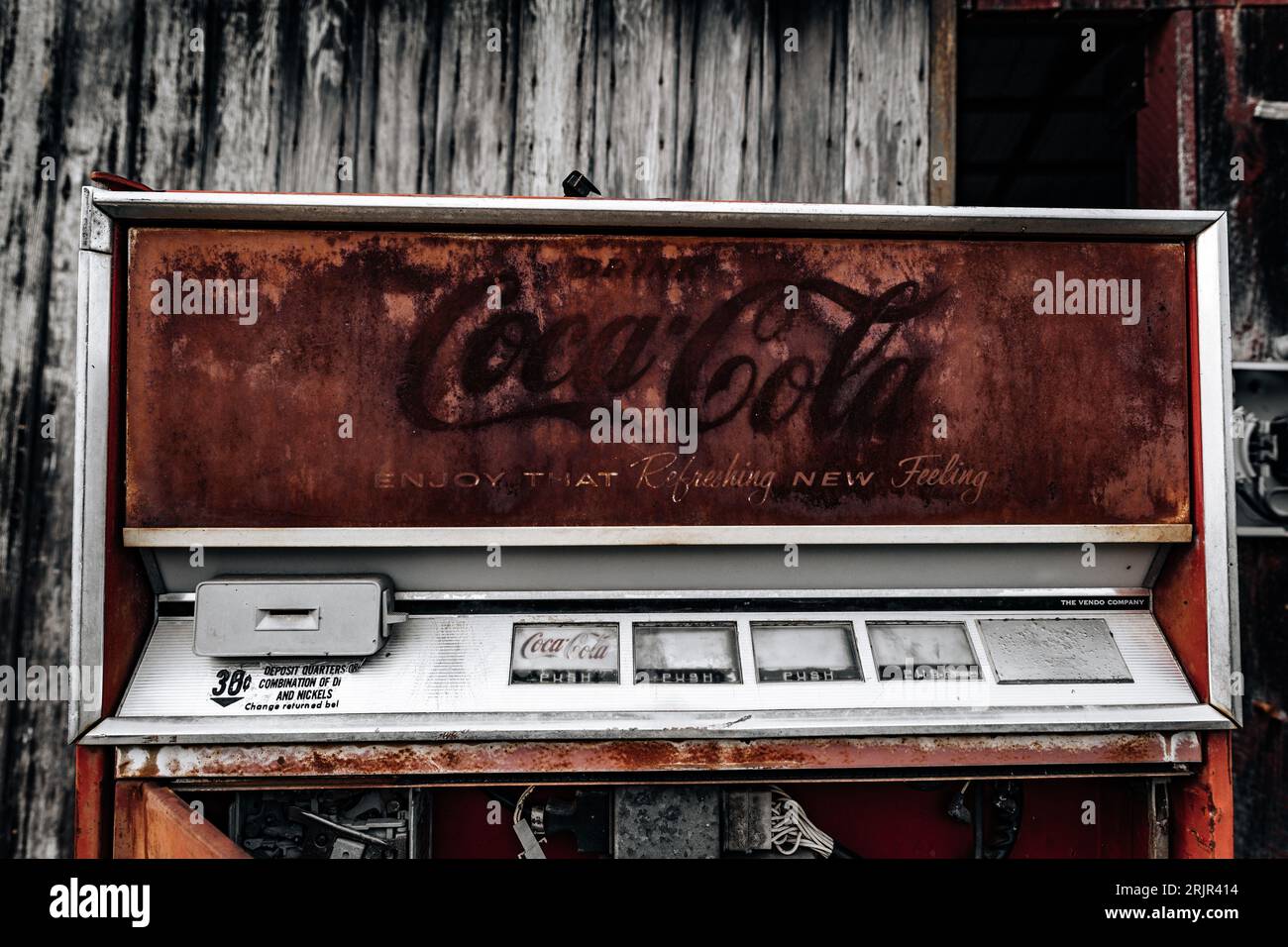 Ein kultiger roter Coca-Cola-Automat vor einem alten, verwitterten Gebäude, der einen zeitlosen und klassischen Look kreiert Stockfoto