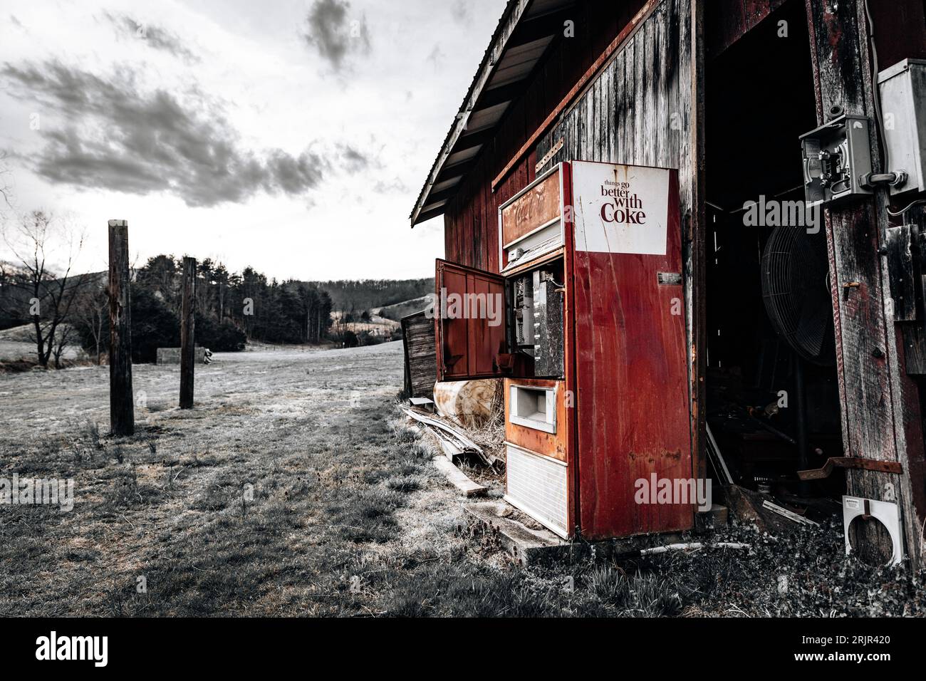 Ein kultiger roter Coca-Cola-Automat vor einem alten, verwitterten Gebäude, der einen zeitlosen und klassischen Look kreiert Stockfoto