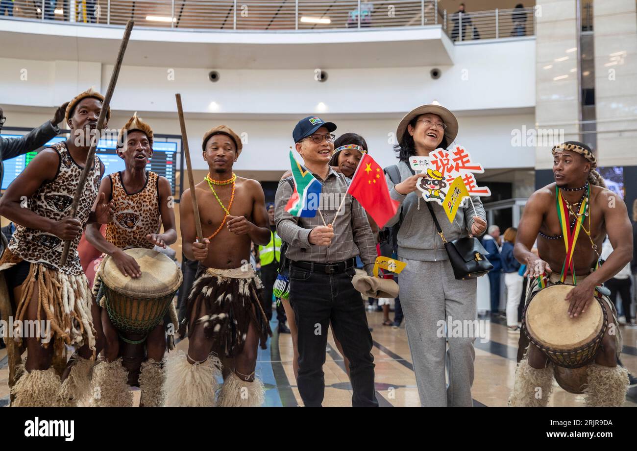 Peking, Südafrika. 29. März 2023. Tänzerinnen und Tänzer interagieren mit Touristen aus China während einer Begrüßungszeremonie am OR Tambo International Airport in Johannesburg, Südafrika, am 29. März 2023. Quelle: Zhang Yudong/Xinhua/Alamy Live News Stockfoto