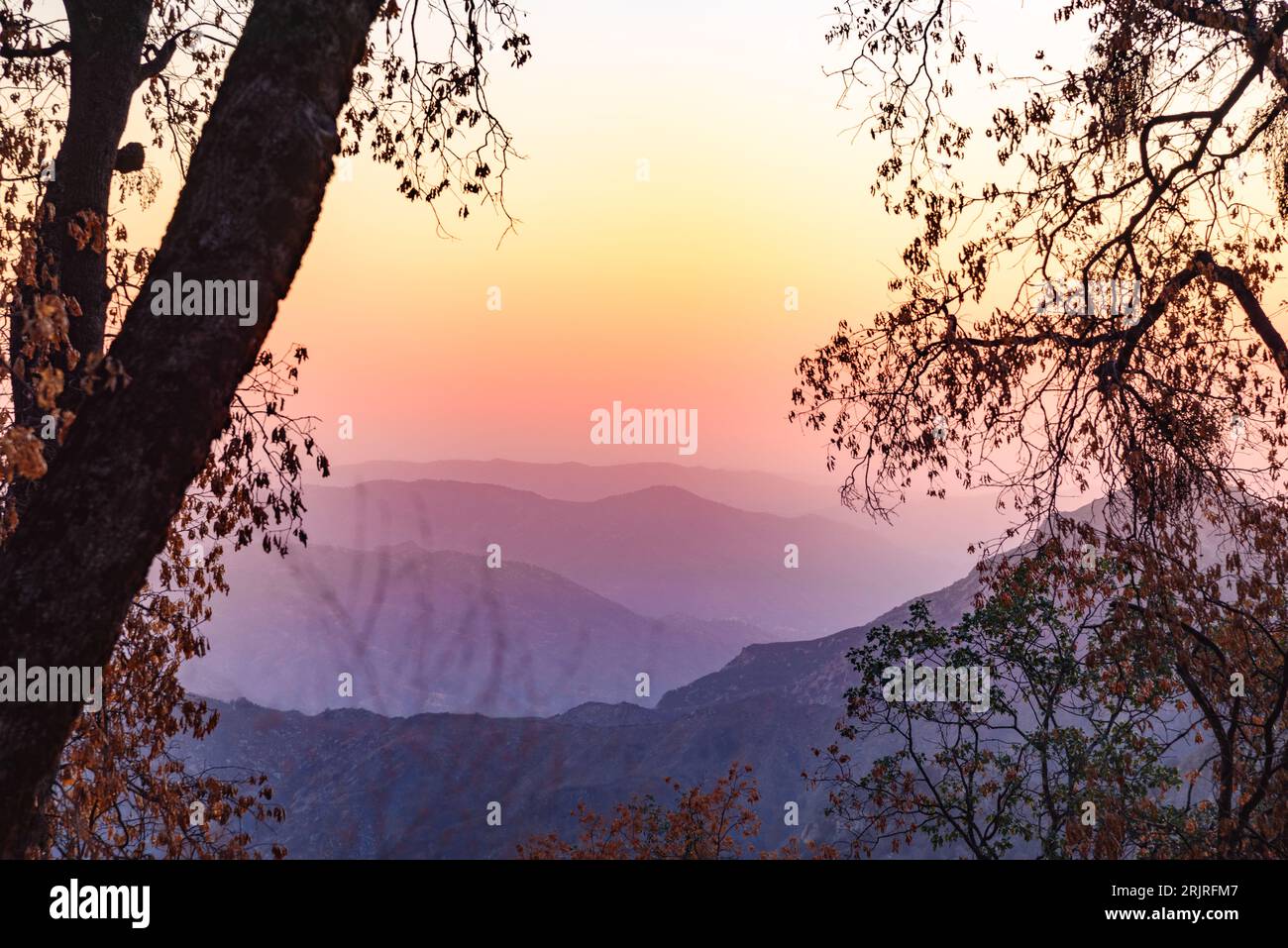 Berge, die in der Abenddämmerung im Herbst von Nebel bedeckt sind Stockfoto