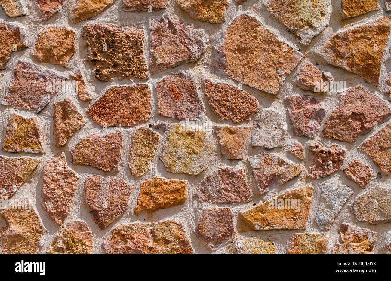 Blick auf die alte Mauer mit Steinen in warmen Farbtönen. Konzept für Hintergründe und Texturen. Stockfoto Blick auf die alte Mauer mit Steinen in warmen Farbtönen. Konzept für Hintergründe und Texturen. Stockfoto
