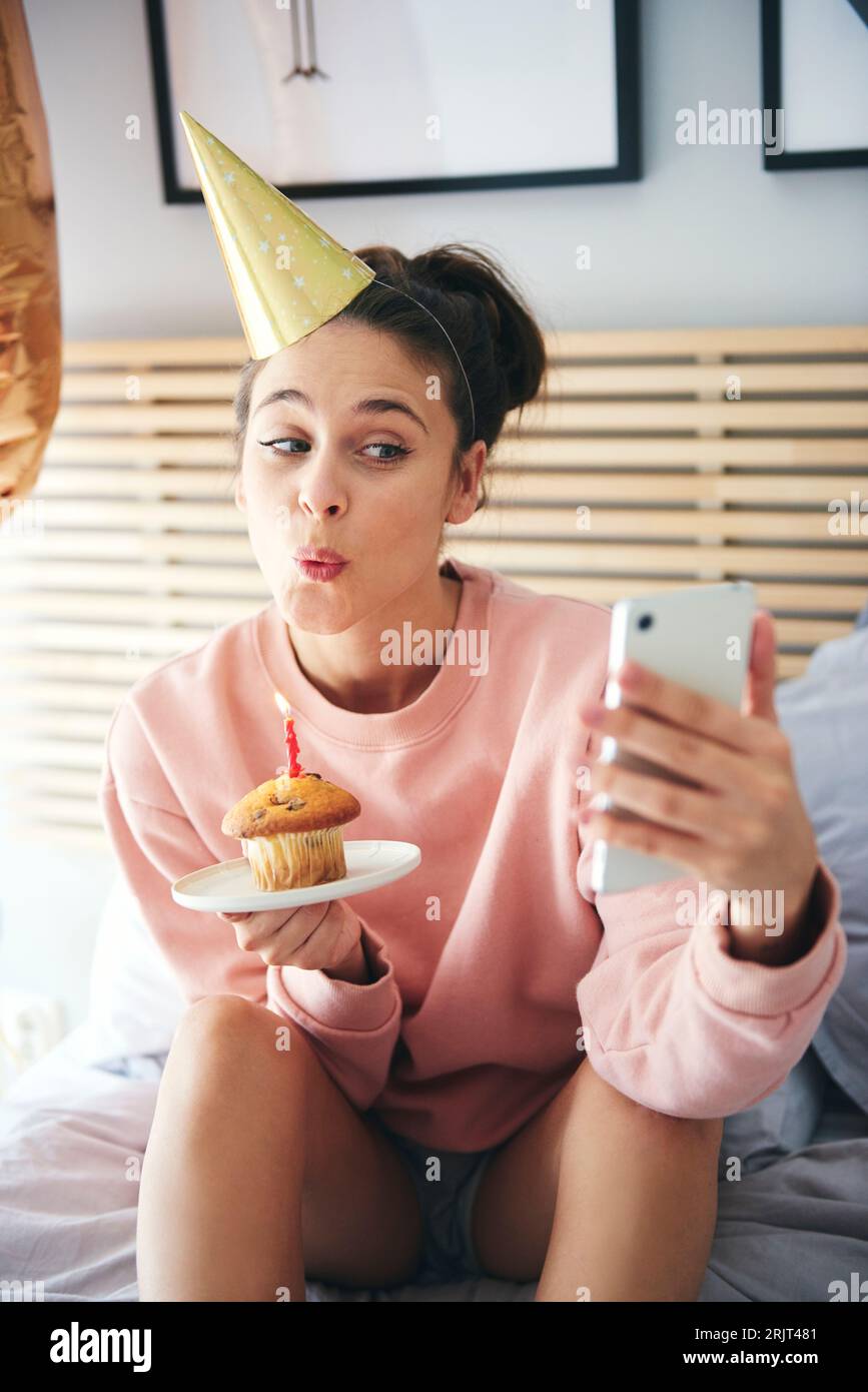 Frau Ausblasen der Kerzen auf der Geburtstagstorte und einen selfie Stockfoto