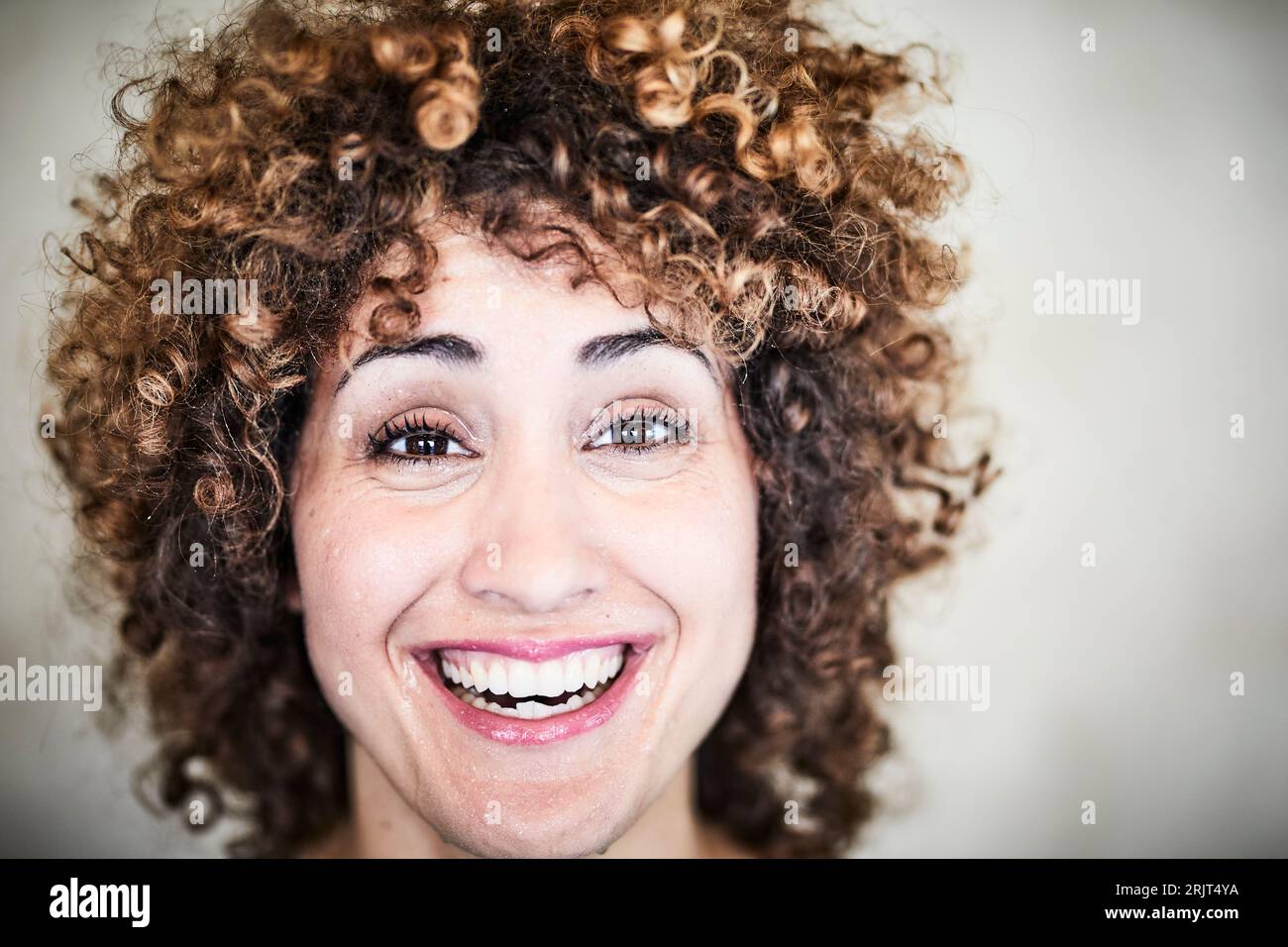 Porträt einer schwitzenden lachenden Frau mit lockigem Haar Stockfoto