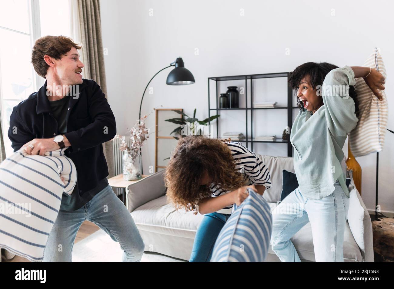 Die lebhafte Familie hat Spaß mit einem Kissenkampf zu Hause Stockfoto
