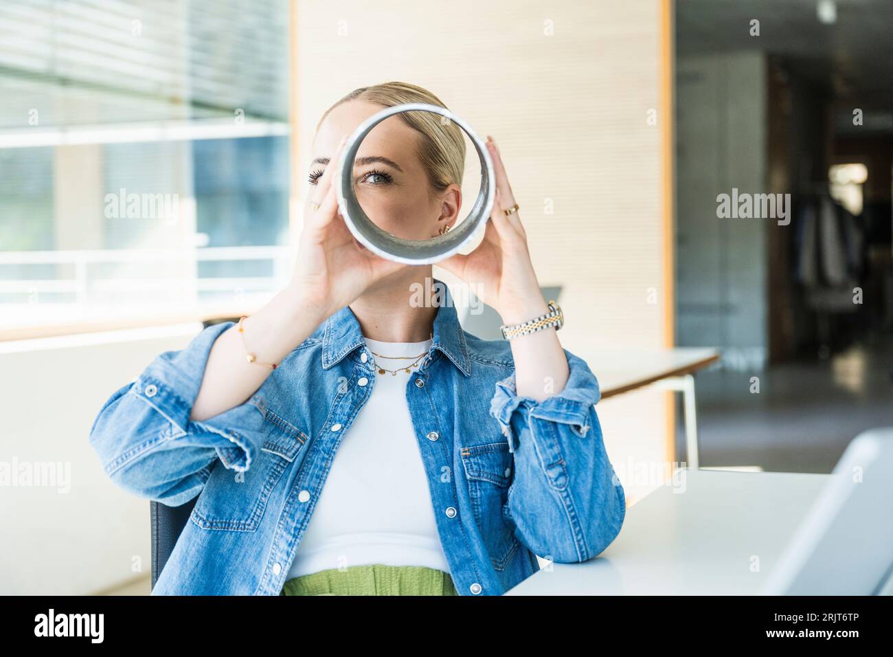 Geschäftsfrau, die durch Metallkreisläufe schaut Stockfoto