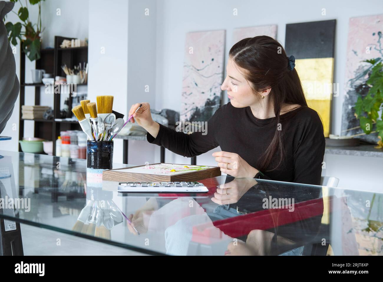 Künstler wählt Pinsel aus, der in der Werkstatt arbeitet Stockfoto