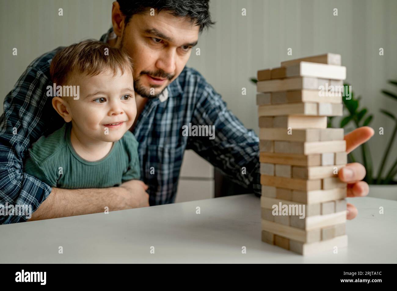 Mann spielt Jenga mit Sohn zu Hause Stockfoto