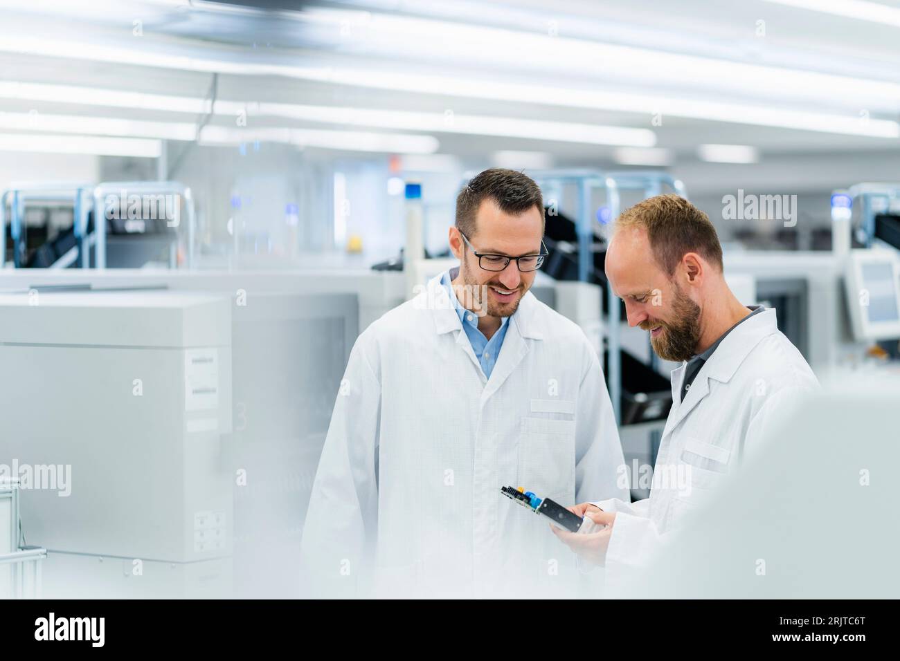 Elektrotechniker in einer Elektronikfabrik, die ein Arbeitstreffen abhalten Stockfoto