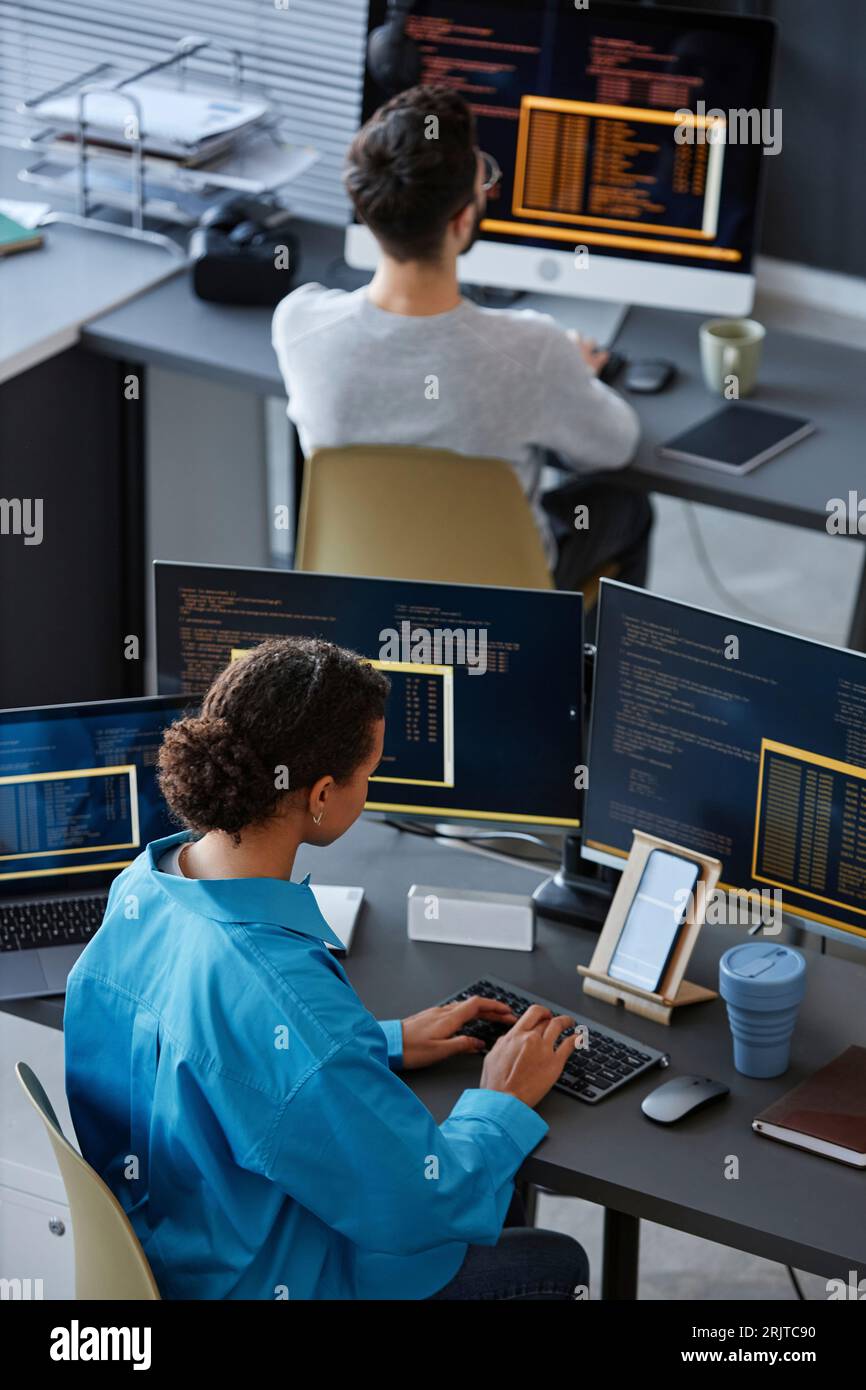 IT-Experten, die an Schreibtischen mit Desktop-Computern arbeiten Stockfoto